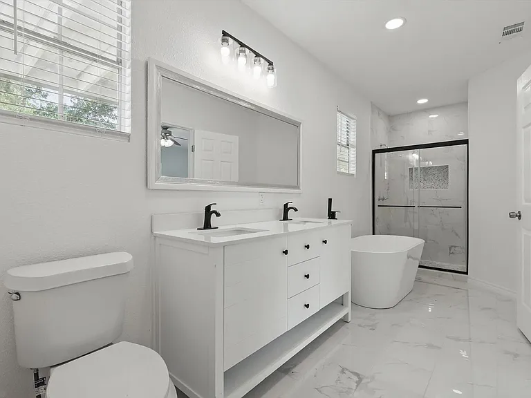 Full bath with a marble finish shower, recessed lighting, double vanity, a freestanding tub, and toilet