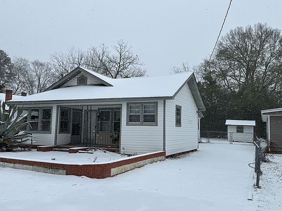 Completely fenced in backyard with dog kennel.