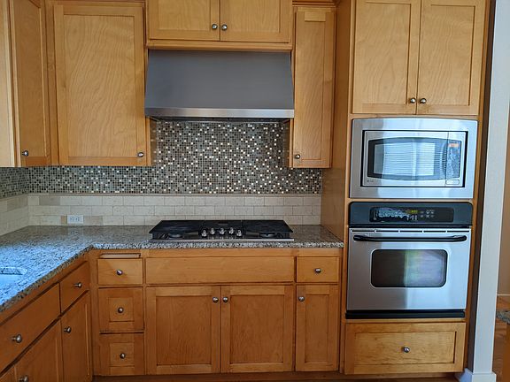 Kitchen with gas range, granite counters, recently installed fridge and dishwasher