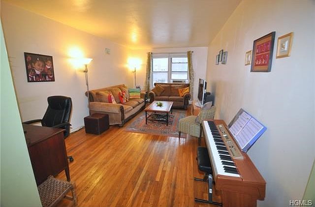 Large Bright living room with hardwood floors opens to the large dining foyer.