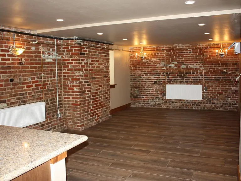 Edge of kitchen countertop looking into dining/living room. White boxes are radiators for heat.