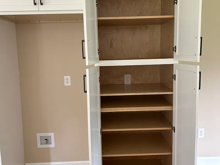 Pantry next to fridge with hidden plug-in for coffee station, microwave, or charging station.