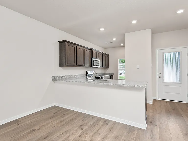 The kitchen has wood cabinetry and a breakfast bar that sits right off of the dining room.