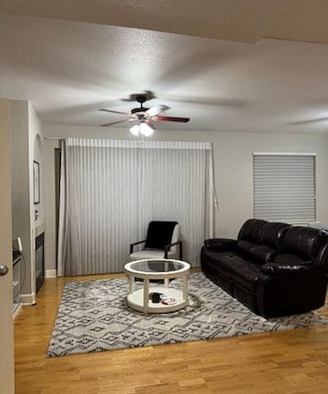 Living room inlcudes 3-seat sofa with two built-in recliners, additional chair, and 50 inch TV.
