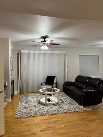 Living room inlcudes 3-seat sofa with two built-in recliners, additional chair, and 50 inch TV.