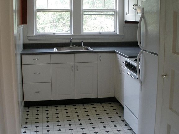 The kitchen windows overlook the large back yard and the trees beyond. Not shown are the updates (stainless steel dishwasher and gas stove, along with new, lighter-colored countertops), which will be completed in a few days.