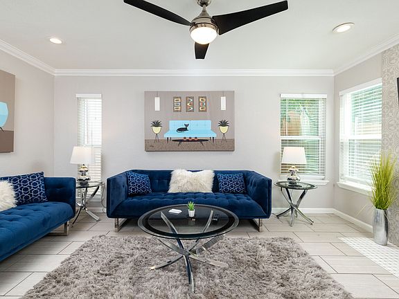 Spacious living room with couch, fireplace and flat screen TV with natural light.