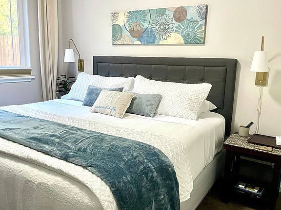 King size memory foam bed with a large closet, dresser, TV and black out blinds and curtains.