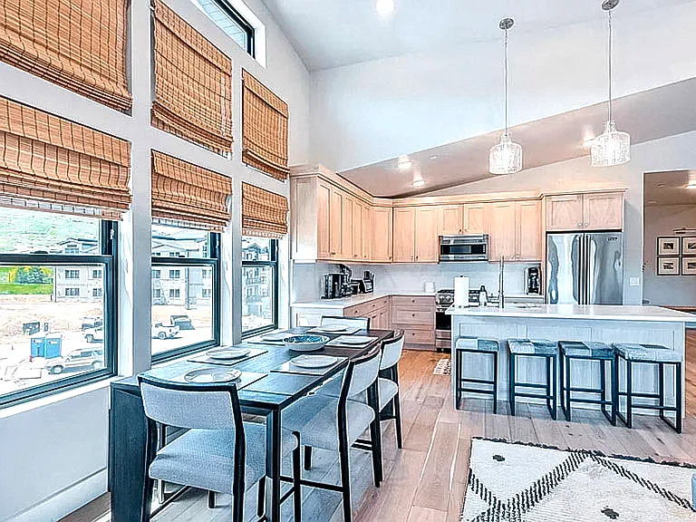 Dining area and kitchen with stunning mountain and town views, chandelier, and seamless flow to the kitchen island