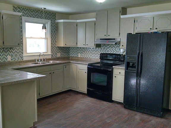 U-shaped kitchen with mosaic tile backsplash, black appliances including dishwater, smoothtop electric range & double door refrigerator