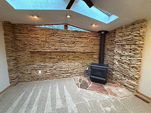 Carpeted den featuring unique stone work