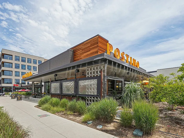 Chic urban restaurant with modern architecture surrounded by green landscaping, perfect for vibrant city dining.