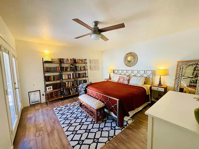 Master bedroom, located downstairs, with door to backyard patio.