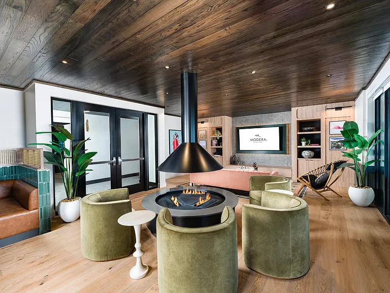 A thoughtfully designed lounge at Modera St. Paul features a modern fireplace, warm finishes, and inviting seating for gathering or unwinding in Dallas.