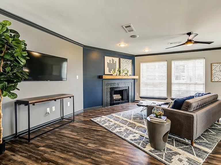 A leasing office with leather couch sitting are and cozy woodburning fireplace is shown.