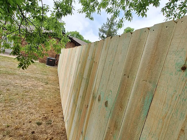 Wooded backyard with new privacy fence.