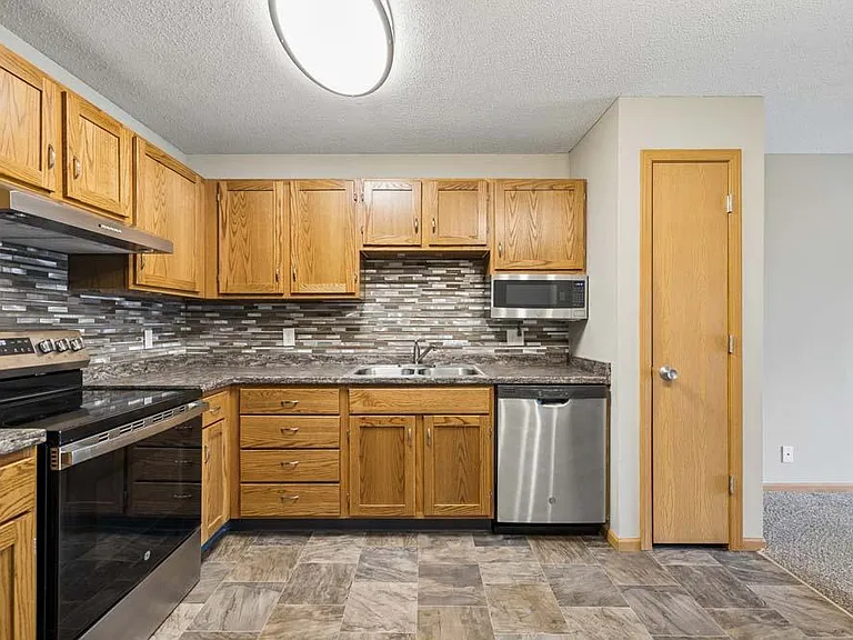 Blending classic charm with practical design, this spacious kitchen features warm wood cabinetry, generous prep space, and a layout that keeps everything within easy reach.