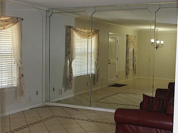 Family room features a mirrored wall .