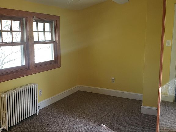 Bedroom with full length mirror. There is actually two full length mirrors that wrap around the house chimney. A ceiling fan is above slightly in view