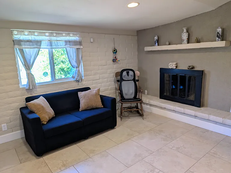 Sunroom with loveseat, pillows, massage chair, fireplace, fire extinguisher