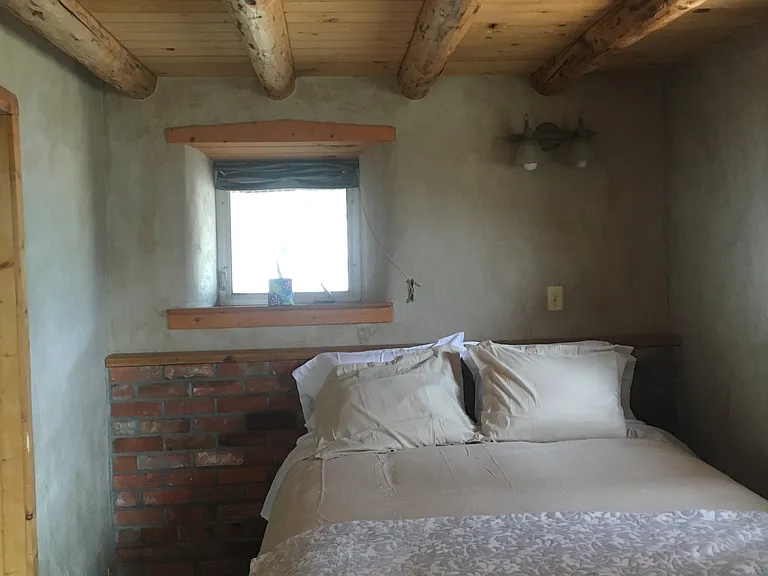 Downstairs bedroom - brick wall has solar tubing for heat during cold months