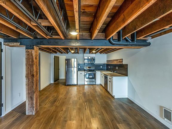 Kitchen has new stainless appliances, open shelving and quartz counters. Plenty of room to add an island for eating or extra storage