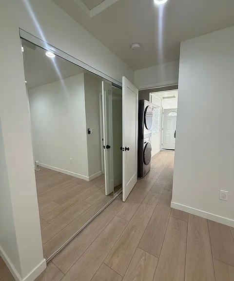 The bedroom door opens to the hallway where the washer and dryer are located.