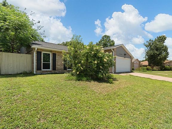 View of front of home featuring brick siding, concrete driveway, and a garage