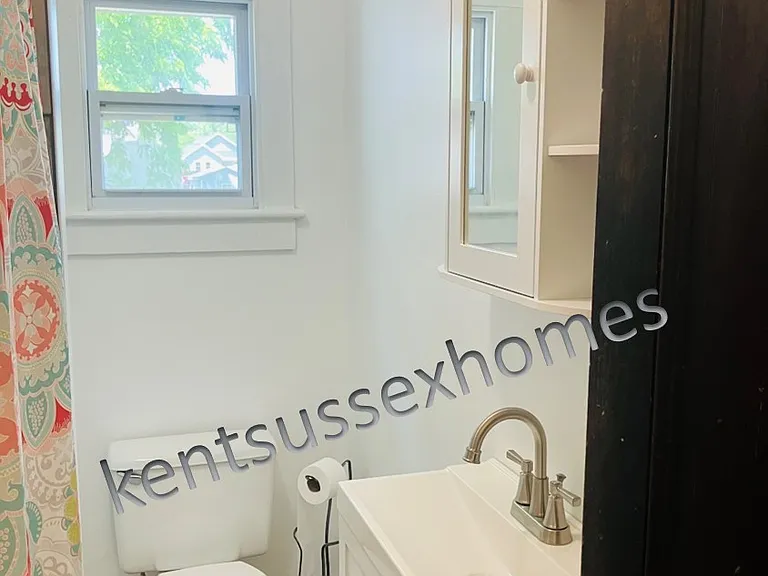 Remodeled bath with new vanity, medicine cabinet, tiled tub surround.