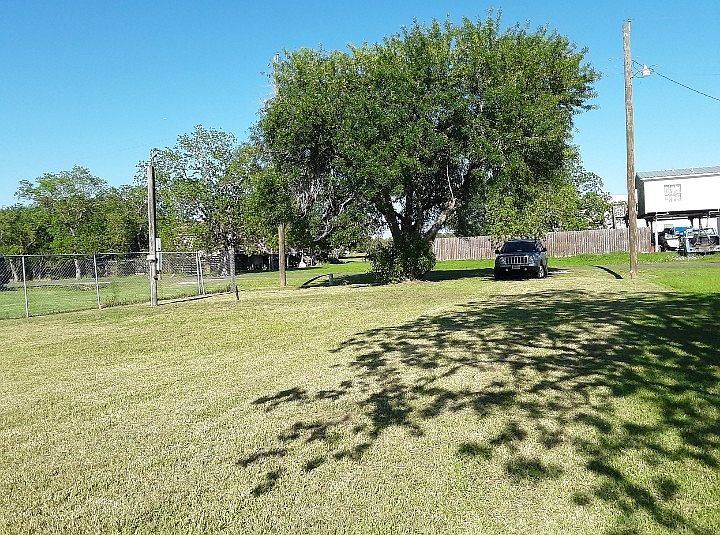 View from the canal at the back, towards the front of the lot. Existing 25' gravel RV pad near power pole on the left