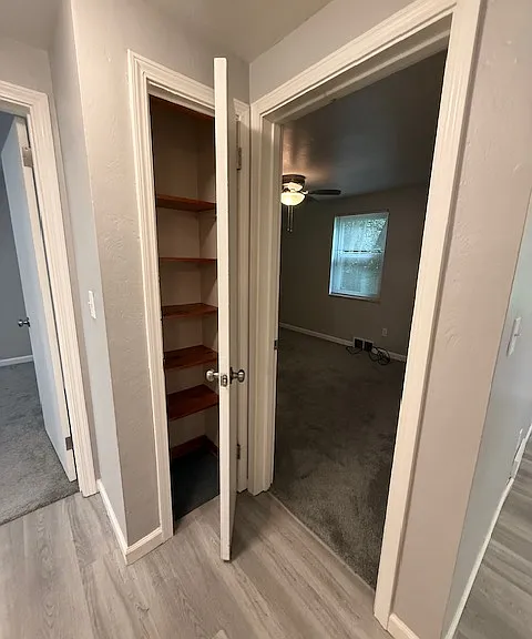 View from kitchen of closet/pantry with entry into main bedroom to the right.