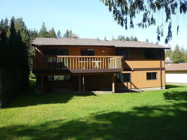 Back of house with large, level yard