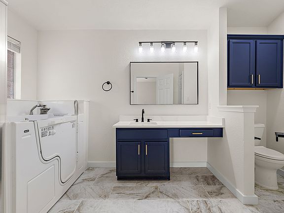 Remodeled master bathroom with updated vanity, flooring, mirrors and quartz countertops. Stand in shower + sit-in Jacuzzi