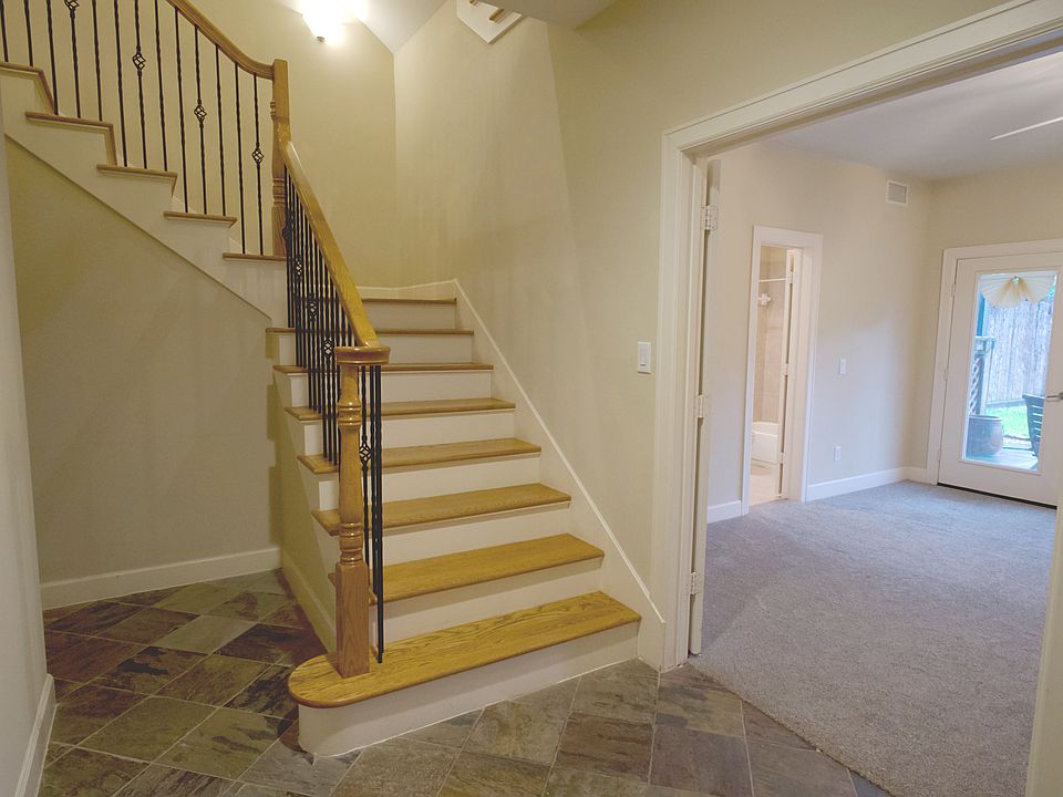 Hallway at entrance, attached two-car garage on the left, and a bedroom with full bath on the right