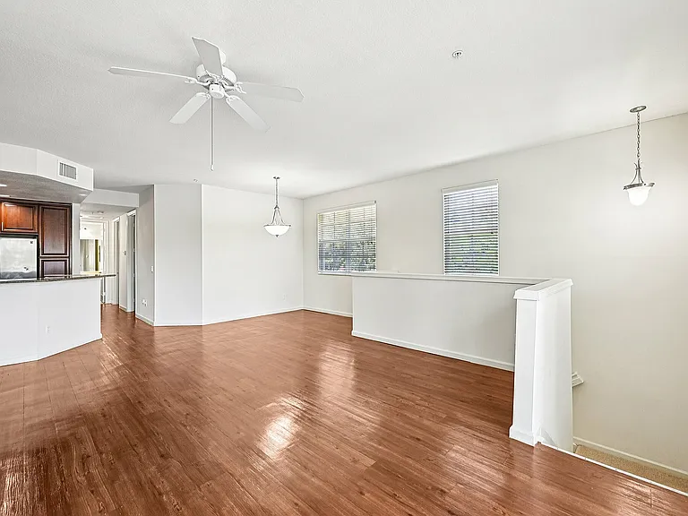 Bright and spacious open-concept living area with modern kitchen, featuring sleek hardwood floors and abundant natural light.