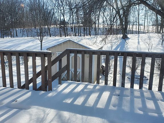rear deck, overlooking wooded area and fenced yard with utlity shed that has electricity