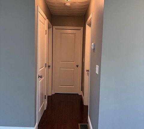 Hallway that leads to basement, bathroom and both bedrooms
