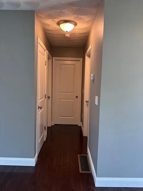 Hallway that leads to basement, bathroom and both bedrooms