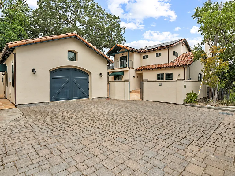 ADU shown with large green door. Adjacent house is for landlord. Parking for ADU is on left on pavers. Private entrance on left under awning.
