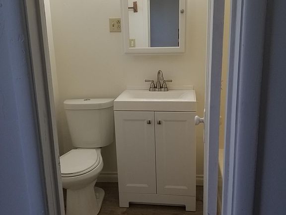 View of bathroom - tub to the right behind the door