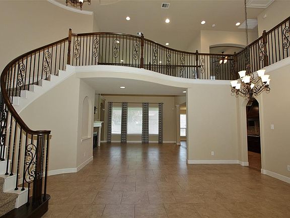 An impressive wrought iron spindle staircase captivates the Foyer.