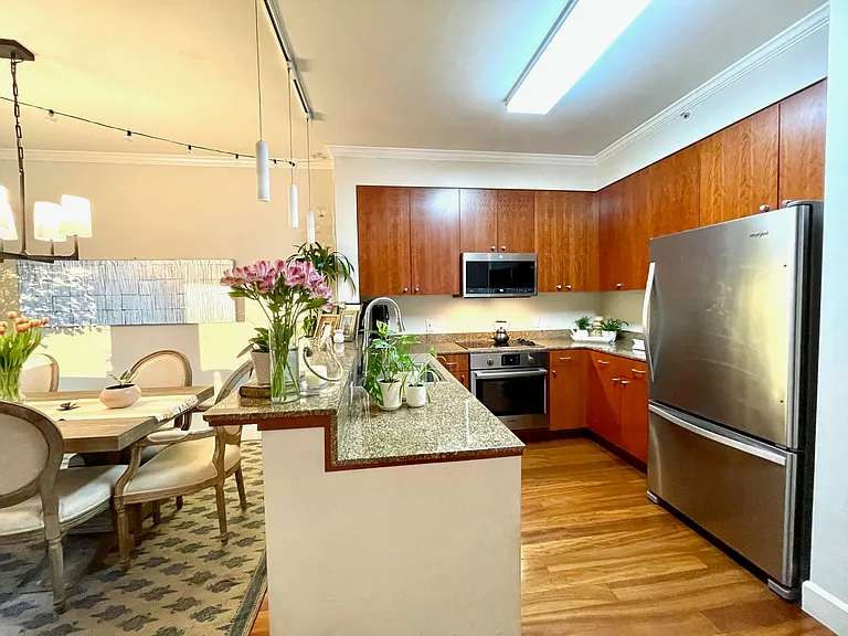 Kitchen with granite counters, cherry cabinets, breakfast bar, and stainless appliances.