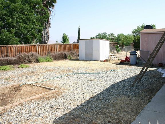 Backyard has 2 sheds, wood fence along back, and chain link fence along sides.