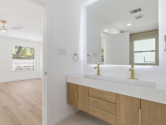 Resort style remodeled primary suite with floating vanity, and a HUGE walk in shower