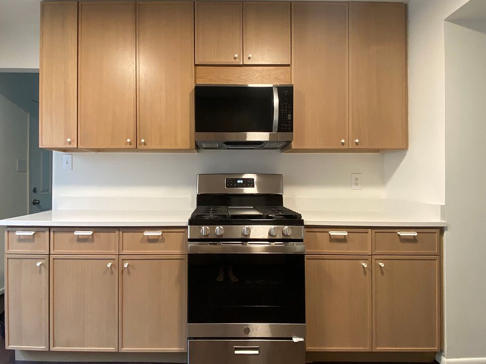 Remodeled kitchen with stainless steel appliances including new gas range and built-in microwave.