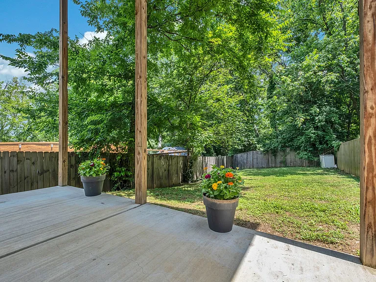 Covered back patio overlooking fenced back yard.
