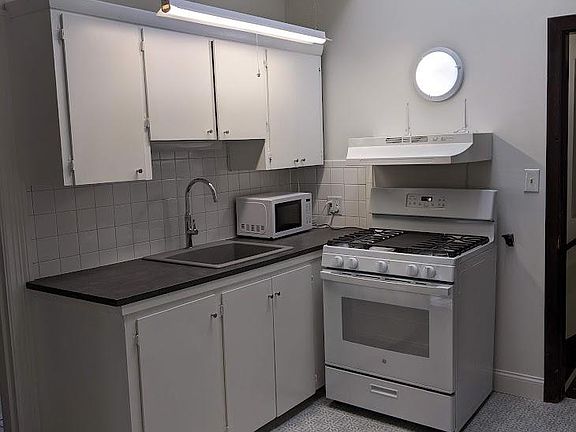 Kitchen view, new sink and faucet, new range, microwave. New Kitchen Countertop.