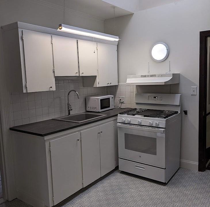 Kitchen view, new sink and faucet, new range, microwave. New Kitchen Countertop.