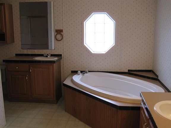 Separate vanities with their own sinks! Commode to the left of smaller vanity, with shower across from commode.