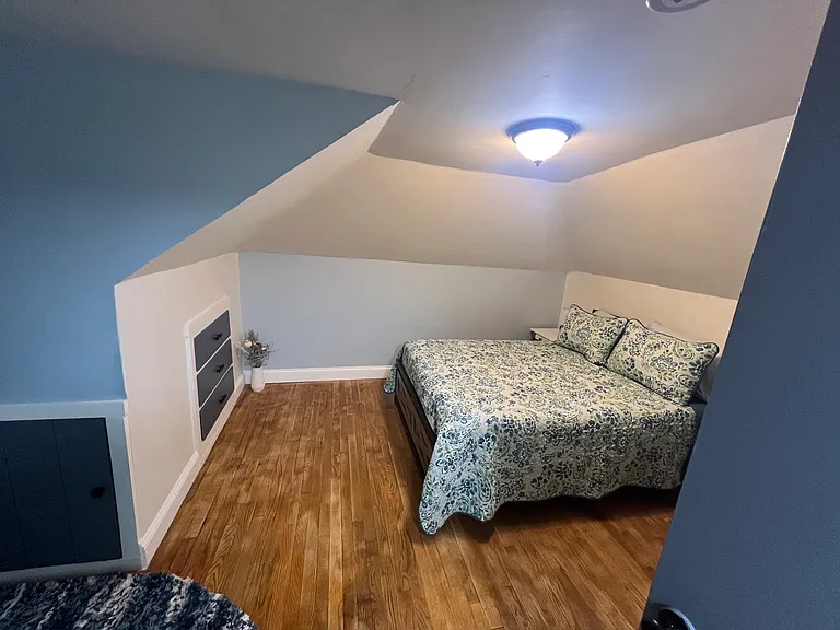 Second floor bedroom with closet, built- in dressers, full size bed, desk, A/C, and TV